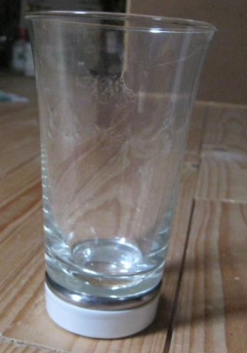 Glas met logo als in fles en wit porseleinen voet 